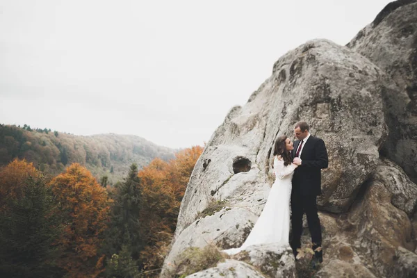 Casal feliz posando sobre bela paisagem nas montanhas — Fotografia de Stock