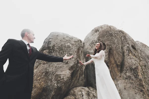 Glückliches Hochzeitspaar posiert über schöner Landschaft in den Bergen — Stockfoto