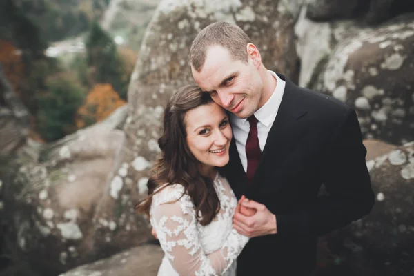 Happy wedding couple posing over beautiful landscape in the mountains — Stock Photo, Image