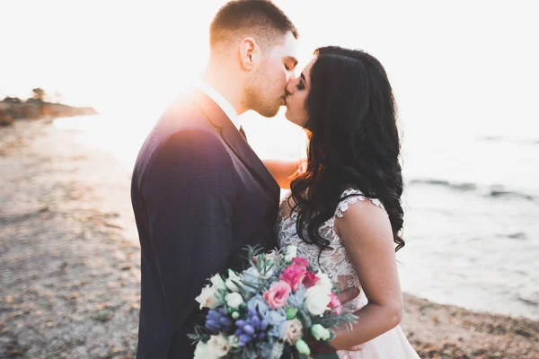 エレガントなスタイリッシュな幸せな結婚式のカップル、花嫁、海と空の背景に豪華な新郎 — ストック写真