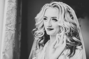 Beyaz elbiseli lüks gelin düğün törenine hazırlanırken poz veriyor.