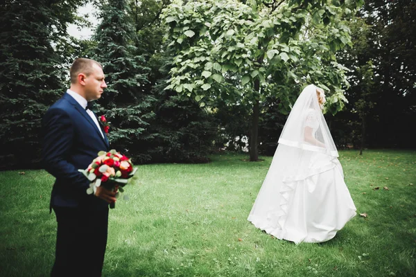 Pareja recién casada corriendo y saltando en el parque mientras se toma de la mano — Foto de Stock