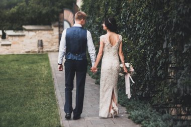 Gelin ve damat el ele tutuşuyor.