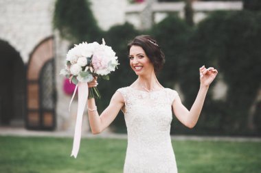 Gelinlik içinde dışarıda poz veren güzel gelin.