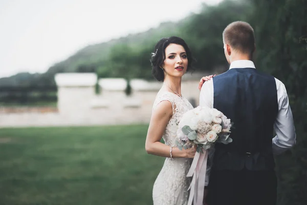 Piękny szczęśliwy ślub para, panna młoda z długą białą sukienką pozowanie w pięknym mieście — Zdjęcie stockowe