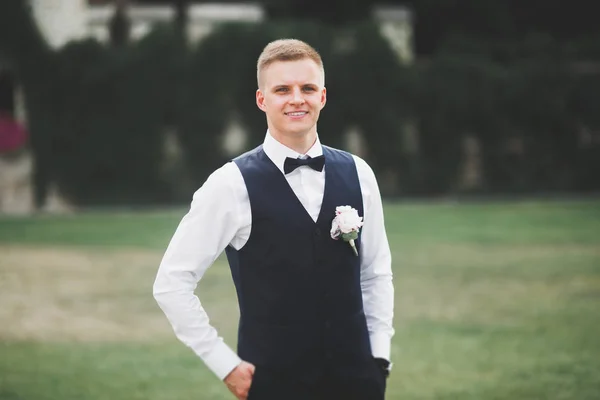 Happy handsome smiling groom posing with boutonniere — Stock Photo, Image