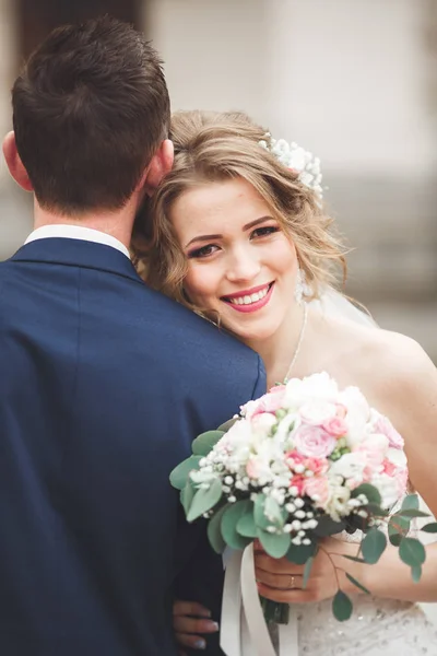 Appena sposati coppia di nozze posa e sposa tenendo in mano bouquet — Foto Stock