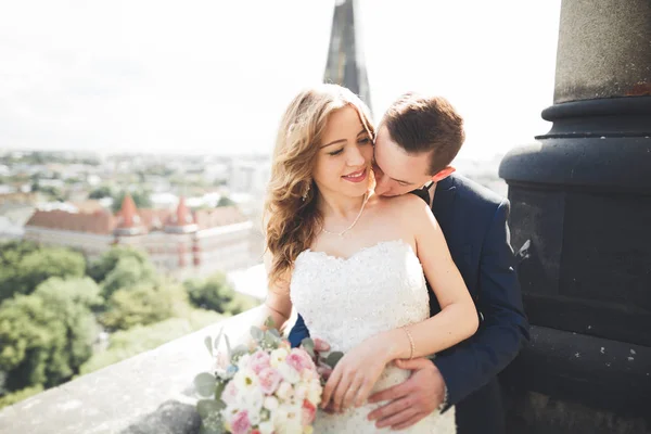 Elegante hermosa pareja de boda besándose y abrazándose en el fondo vista panorámica del casco antiguo — Foto de Stock