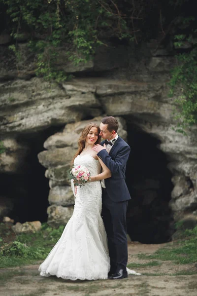 Allegro matrimonio coppia posa nea rocce — Foto Stock