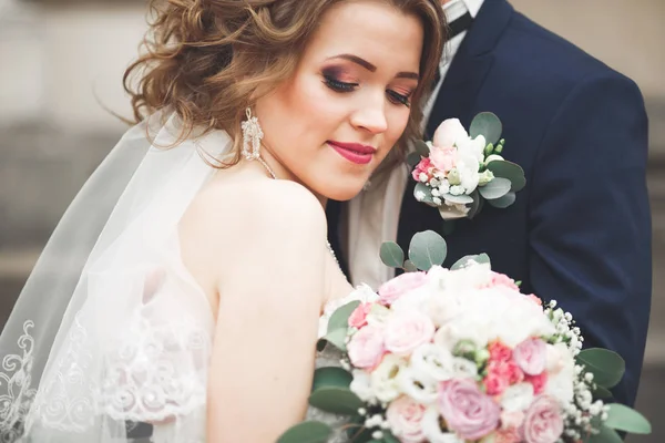 Appena sposati coppia di nozze posa e sposa tenendo in mano bouquet — Foto Stock