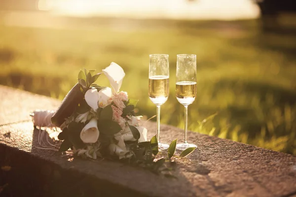 Bouquet da sposa e due bicchieri con champagne — Foto Stock