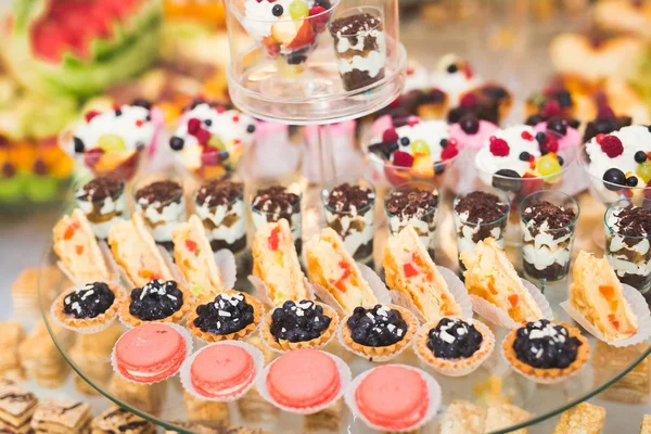 Läckra och välsmakande dessert bord med cupcakes skott i receptionen närbild — Stockfoto