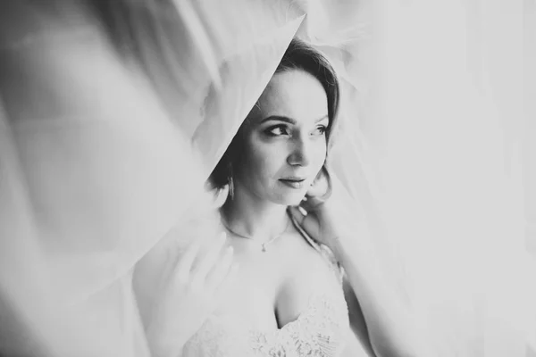 Linda noiva em roupão posando e se preparando para o rosto cerimônia de casamento em uma sala — Fotografia de Stock