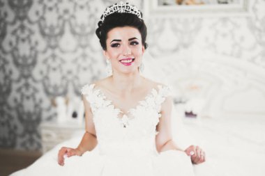 Beyaz elbiseli lüks gelin düğün törenine hazırlanırken poz veriyor.