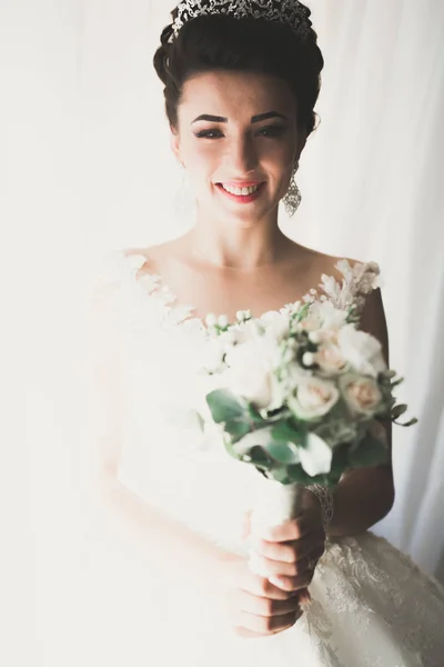 Linda noiva em roupão posando e se preparando para o rosto cerimônia de casamento em uma sala — Fotografia de Stock