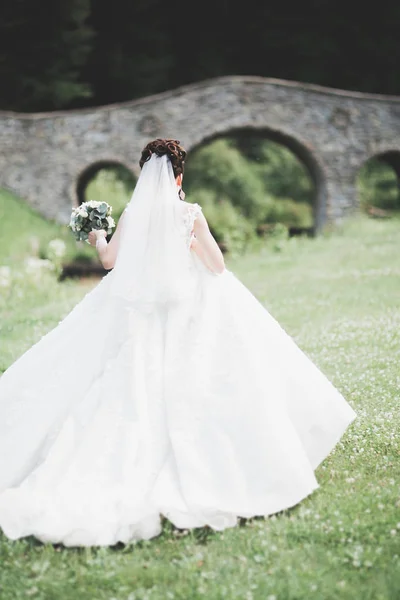 Retrato de novia impresionante con el pelo largo posando con gran ramo — Foto de Stock