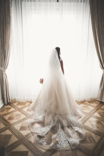 Retrato de novia impresionante con el pelo largo posando con gran ramo — Foto de Stock