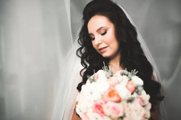 Mempelai wanita cantik mengenakan gaun pengantin dengan bulu dengan riasan mewah dan gaya rambut, studio pemotretan dalam ruangan — Stok Foto