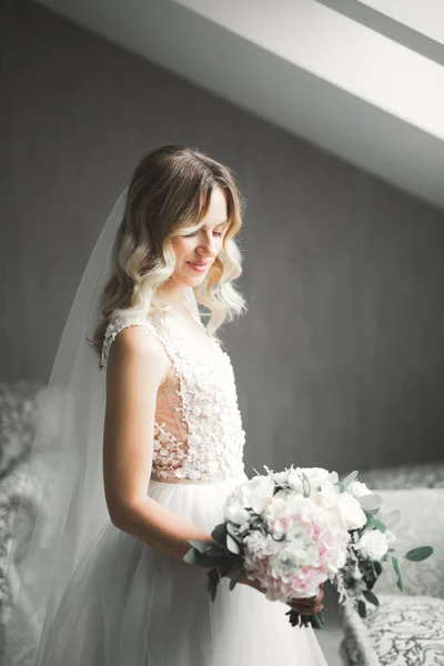 Noiva de luxo em vestido branco posando enquanto se prepara para a cerimônia de casamento — Fotografia de Stock