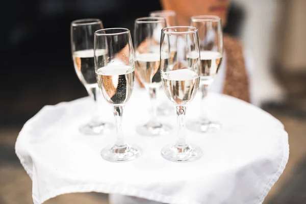 Cameriere che serve bicchieri con champagne su un vassoio — Foto Stock