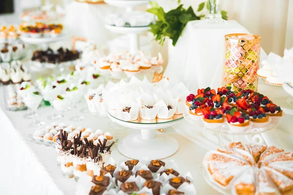 Deliciosos dulces en el buffet de dulces de boda con postres, cupcakes — Foto de Stock