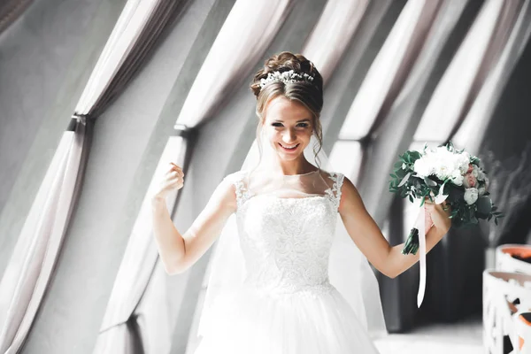 Porträt der atemberaubenden Braut mit langen Haaren posiert mit großem Strauß — Stockfoto