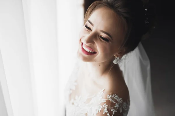 Splendida sposa in accappatoio in posa e preparazione per la cerimonia di nozze faccia in una stanza — Foto Stock