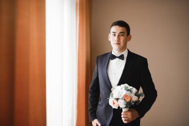 Cüppeli muhteşem gelin bir odada düğün töreni için poz veriyor ve hazırlanıyor.