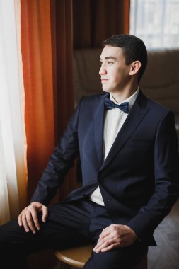 Güzel adam, damat poz veriyor ve düğüne hazırlanıyor.