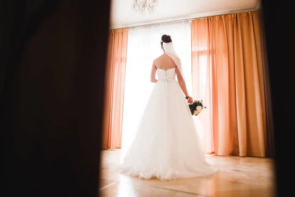 Novia de lujo en vestido blanco posando mientras se prepara para la ceremonia de boda — Foto de Stock