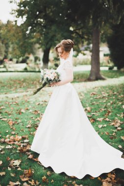 Gelin çiçekli büyük ve güzel bir düğün buketi tutuyor.