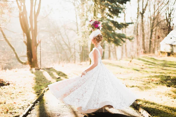 Linda noiva girando com vestido perfeito no parque — Fotografia de Stock