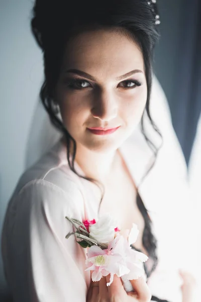 Linda noiva em roupão posando e se preparando para o rosto cerimônia de casamento em uma sala — Fotografia de Stock