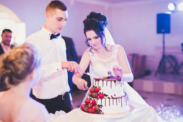 Novia y novio en la boda de corte de la torta de boda — Foto de Stock