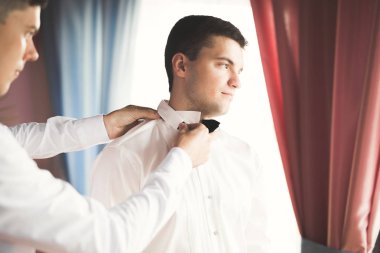 Güzel adam, damat poz veriyor ve düğüne hazırlanıyor.