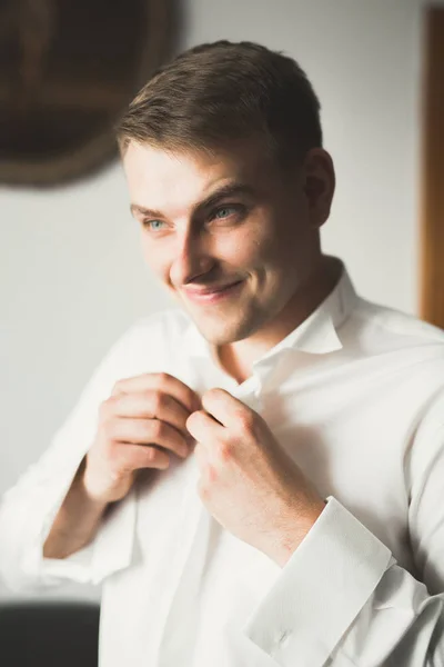 Jovem homem bonito relaxando em seu apartamento em um hotel após reunião de negócios — Fotografia de Stock