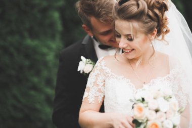 Genç ve güzel bir çift parkta öpüşüyor ve gülümsüyor.