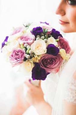 Beyaz elbiseli lüks gelin düğün törenine hazırlanırken poz veriyor.