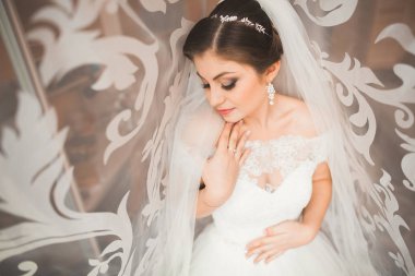 Beyaz elbiseli lüks gelin düğün törenine hazırlanırken poz veriyor.