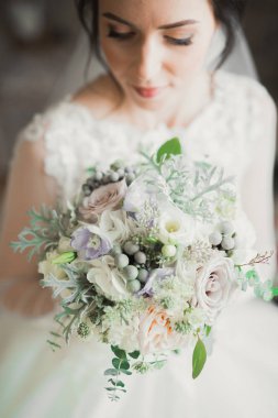 Beyaz elbiseli lüks gelin düğün törenine hazırlanırken poz veriyor.