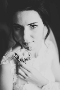 Gelin çiçekli büyük ve güzel bir düğün buketi tutuyor.