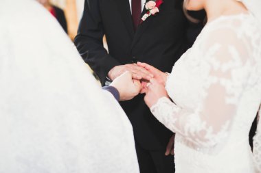 Gelin ve damat alyanslarını değiş tokuş ediyorlar. Şık bir çift töreni.