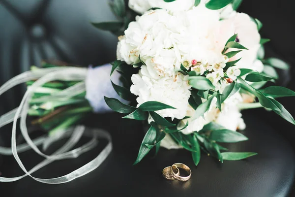 Imagem tonificada bonita com anéis de casamento contra o fundo de um buquê de flores — Fotografia de Stock