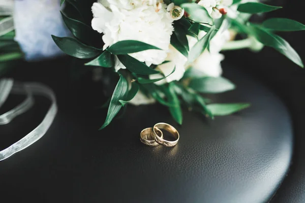 Schöne getönte Bild mit Eheringen vor dem Hintergrund eines Straußes von Blumen — Stockfoto