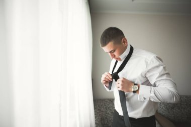 Güzel adam, damat poz veriyor ve düğüne hazırlanıyor.