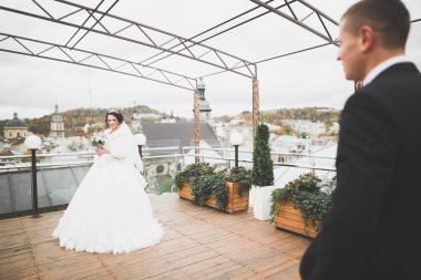 Güzel, mutlu bir düğün çifti, güzel şehirde uzun beyaz elbiseli bir gelin.