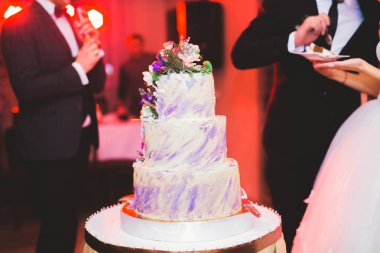 Masada süslü düğün pastası var.