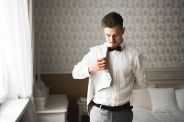 Güzel adam, damat poz veriyor ve düğüne hazırlanıyor.