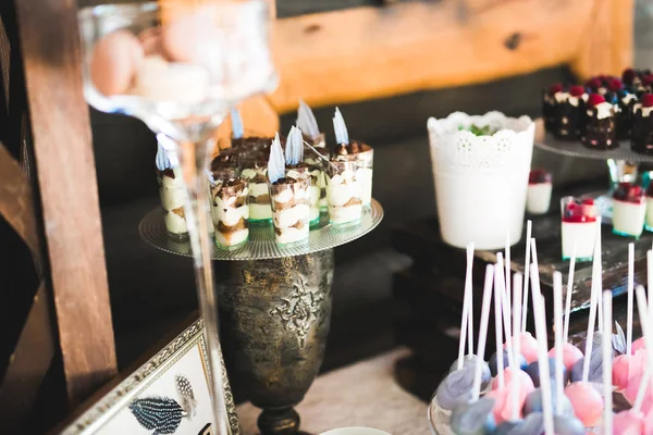 Deliciosos dulces en el buffet de dulces de boda con postres, cupcakes —  Fotos de Stock