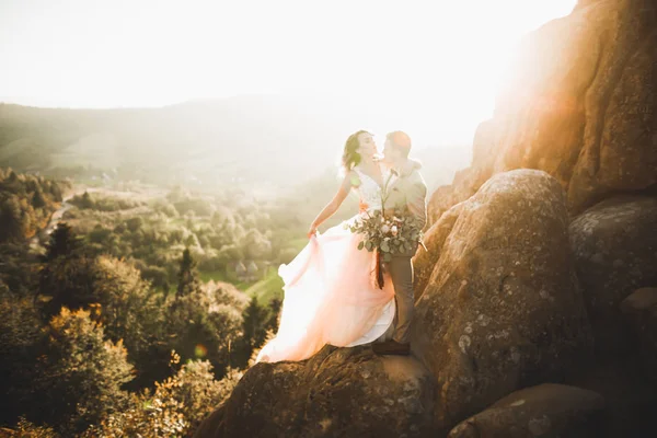 Hermosa pareja de boda besándose y abrazándose cerca de la montaña con vista perfecta — Foto de Stock